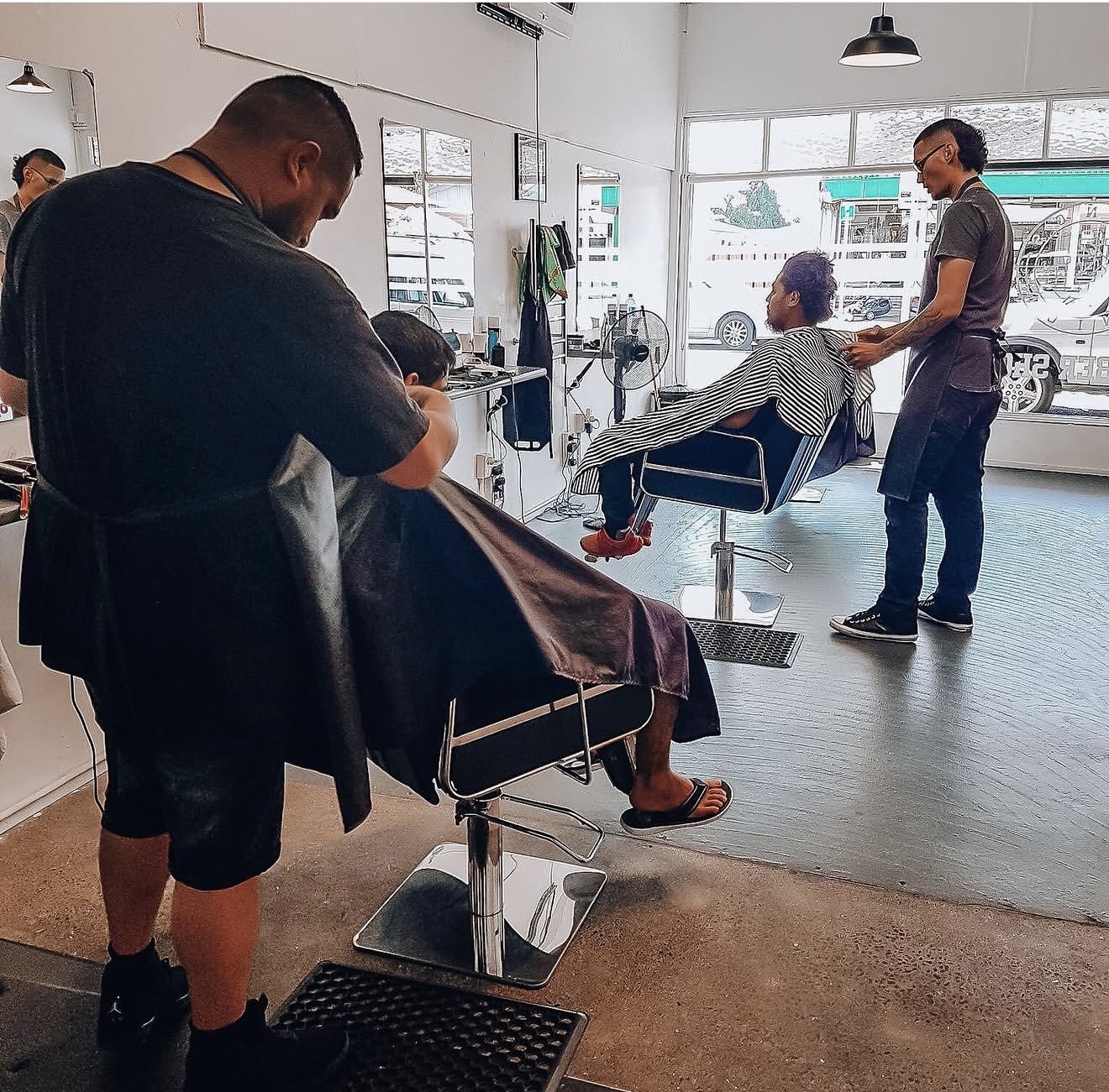 Jabez and Karry cutting hair at Kings Union Barbershop in 2018